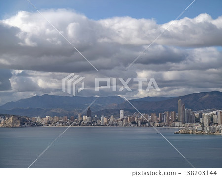 Dynamic weather highlights metropolitan seaside with towering buildings and mountain vistas in background Dynamic weather highlights metropolitan seaside with towering buildings and mountain vistas in background 138203144