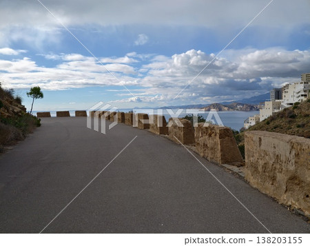 Serene seaside ambiance, Beachside approach framed by stones with calm sea and inviting atmosphere Serene seaside ambiance, Beachside approach framed by stones with calm sea and inviting atmosphere 138203155