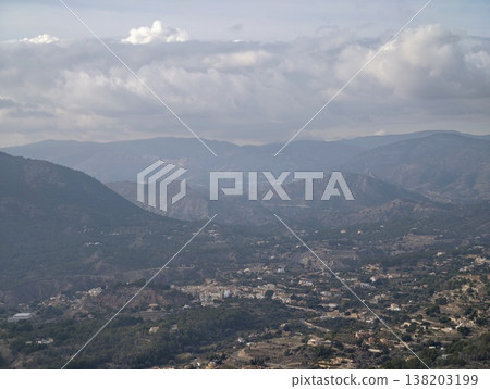 Peaceful valley with misty peaks, Quiet valley with rolling hills and faint mountain outlines at dawn Peaceful valley with misty peaks, Quiet valley with rolling hills and faint mountain outlines at dawn 138203199