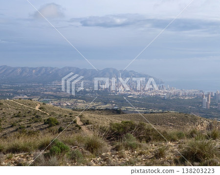 Distant cityscape through natural surroundings, Hillside framing with city skyscrapers on coast Distant cityscape through natural surroundings, Hillside framing with city skyscrapers on coast 138203223