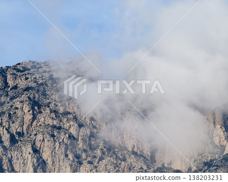 Dense fog conceals ledges and highlights intricate geological formations during exploration 138203231