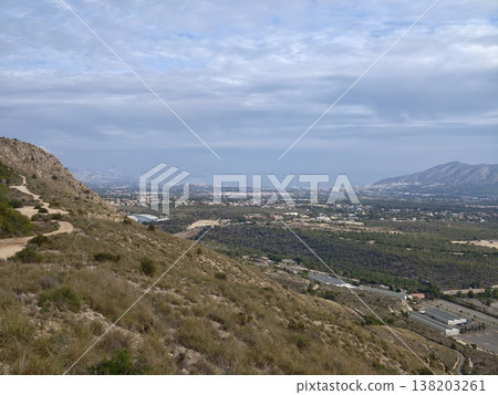 Charming hiking path through rocky terrain offering breathtaking views of nature and nearby urban backdrop Charming hiking path through rocky terrain offering breathtaking views of nature and nearby urban backdrop 138203261
