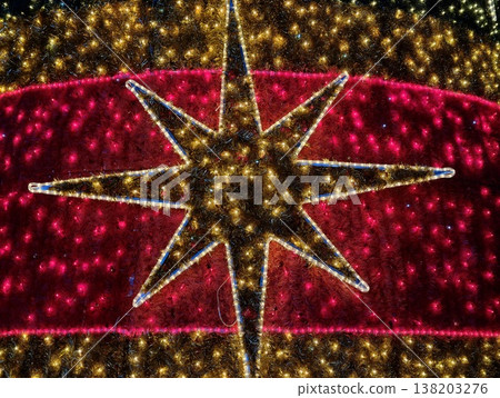 Striking giant star pattern radiating brilliance across vivid crimson background for festivities Striking giant star pattern radiating brilliance across vivid crimson background for festivities 138203276