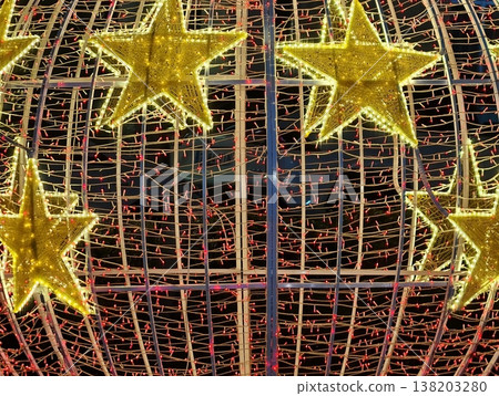 Celebratory seasonal city display with softly shining stars wrapped around metal framework Celebratory seasonal city display with softly shining stars wrapped around metal framework 138203280