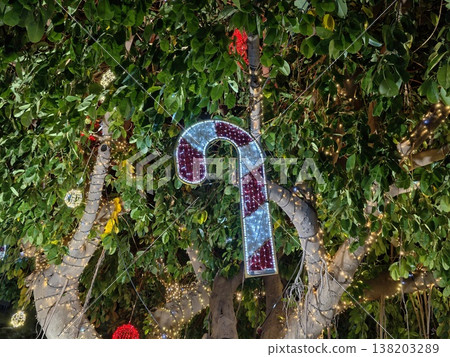 Whimsical garden installation featuring glass mosaic treble clef amid ivy and flower accents 138203289