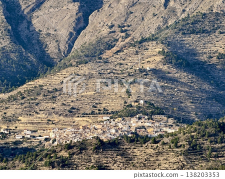 Secluded settlement amid rugged terrain, Remote mountain hamlet with sparse vegetation and dramatic ridges Secluded settlement amid rugged terrain, Remote mountain hamlet with sparse vegetation and dramatic ridges 138203353