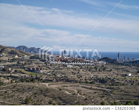 Cliffside village overlooking ocean, Hillside town with rooftops and distant ocean backdrop Cliffside village overlooking ocean, Hillside town with rooftops and distant ocean backdrop 138203365
