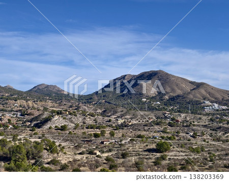 Stretches of arid grassland leading to hills beneath clear blue sky suitable for outdoor activities 138203369
