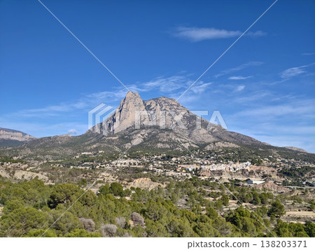 Impressive limestone summit soaring above lush greenery with welcoming trails and clear blue skies Impressive limestone summit soaring above lush greenery with welcoming trails and clear blue skies 138203371
