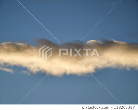 Sunlit textured clouds adorn peaceful sky, Calm horizon with radiant clouds stretches across azure expanse 138203387