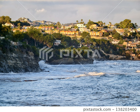 Rugged coast with crashing waves, Powerful ocean waves surge against steep rocky shoreline vibrantly 138203400