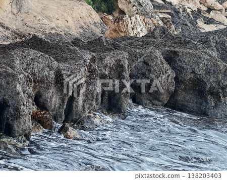 Waves over weathered rocks and pools, Sea surge causes erosion on coastal rock formations and pools Waves over weathered rocks and pools, Sea surge causes erosion on coastal rock formations and pools 138203403