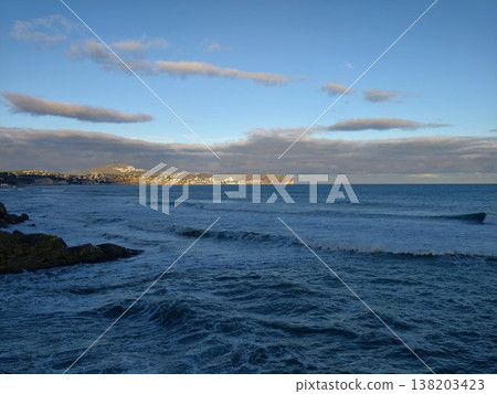 Coastline with town, Rocky shoreline meets quiet bay, Distant settlement along rugged coastal edge 138203423