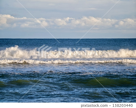 Vivid coastal wave in motion, Energetic wave with foam spray and reflective sunlight sparkle Vivid coastal wave in motion, Energetic wave with foam spray and reflective sunlight sparkle 138203440