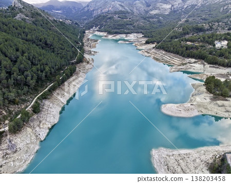 Expansive view of water and mountains, Vast panoramic image of forested peaks and water reservoir Expansive view of water and mountains, Vast panoramic image of forested peaks and water reservoir 138203458