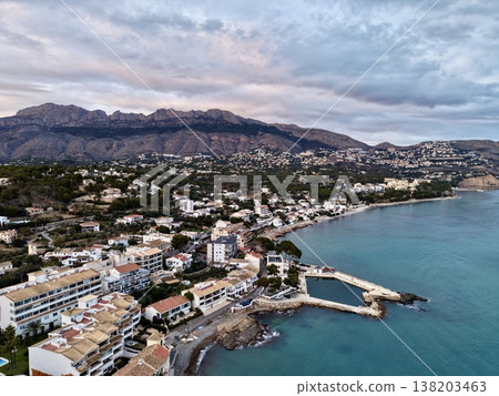 Cloudy harbor with calm surroundings, Overcast shoreline with clustered houses and muted turquoise water Cloudy harbor with calm surroundings, Overcast shoreline with clustered houses and muted turquoise water 138203463