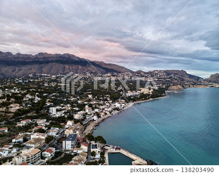 Serene harbor under pastel morning sky, Tranquil seaside settlement with turquoise bay and mountain views Serene harbor under pastel morning sky, Tranquil seaside settlement with turquoise bay and mountain views 138203490