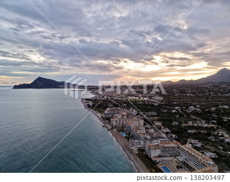 Seaside evening with glowing sky, Serene sunset illuminating shoreline with hotels and palm trees 138203497