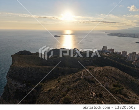 Sunrise illuminating rugged city skyline, Morning glow highlights cliffside trails and distant cityscape Sunrise illuminating rugged city skyline, Morning glow highlights cliffside trails and distant cityscape 138203502