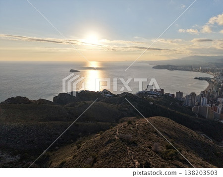Urban cliffs reflect sunset glow, Aerial view of city at sunset with cliffs and reflections Urban cliffs reflect sunset glow, Aerial view of city at sunset with cliffs and reflections 138203503