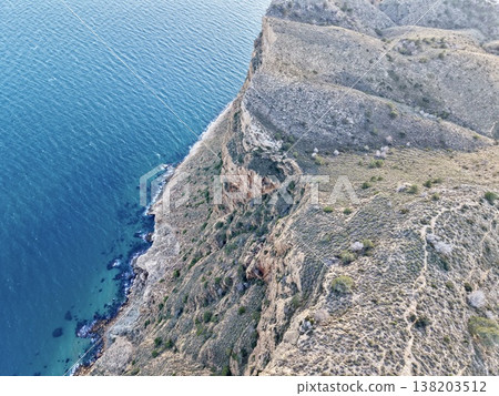 Steep edge overlooking vegetation, Rugged promontory offers challenging landscape for adventurers 138203512