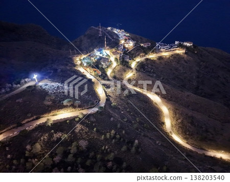 Elevated vantage point revealing peaceful journey through illuminated winding mountain roads at night Elevated vantage point revealing peaceful journey through illuminated winding mountain roads at night 138203540