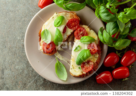 Hot open sandwiches with mozzarella, tomatoes and basil. 138204302