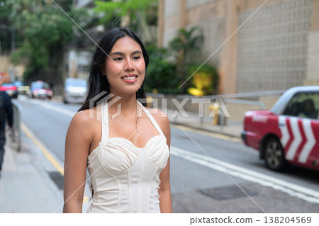 Young Asian Woman Smiling on Street with Hong Kong Taxi Background 138204569