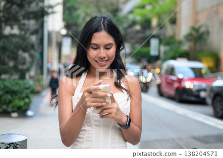 Young Asian Woman Using Smartphone on Hong Kong Street 138204571