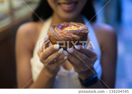 Young Asian Woman Holding Fresh Egg Tart in Hong Kong 138204595