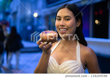 Thai Woman Holding Egg Tart on Hong Kong Street Thai Woman Holding Egg Tart on Hong Kong Street 138204596