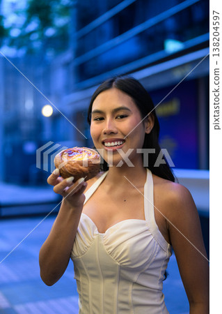 Thai Woman Holding Egg Tart on Hong Kong Street Thai Woman Holding Egg Tart on Hong Kong Street 138204597
