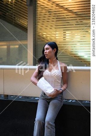 Thai Woman Holding Egg Tart on Hong Kong Street 138204602
