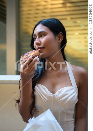Thai Woman Holding Egg Tart on Hong Kong Street Thai Woman Holding Egg Tart on Hong Kong Street 138204608