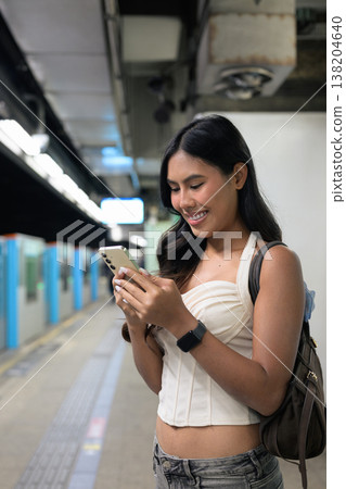 Thai Woman Using Smartphone at Hong Kong Subway Station Platform Thai Woman Using Smartphone at Hong Kong Subway Station Platform 138204640