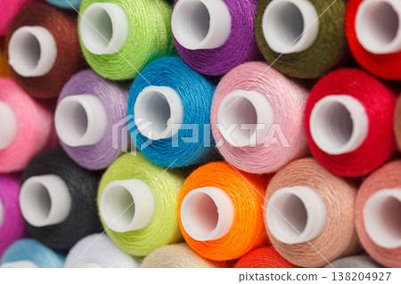 multi-colored spools of sewing thread on a white background 138204927