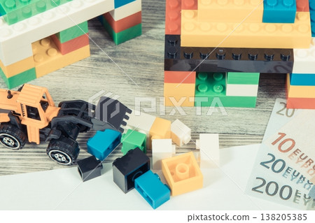 Houses made of toy blocks, miniature excavator, mortgage agreement form and euro banknotes Houses made of toy blocks, miniature excavator, mortgage agreement form and euro banknotes 138205385