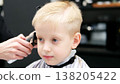 Little boy receiving a haircut at barbershop 138205422