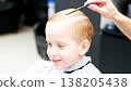 Child boy getting haircut in barbershop salon 138205438