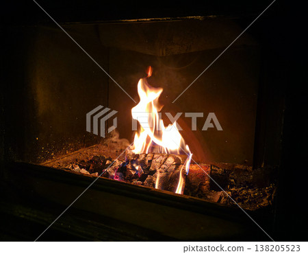 Tongues of flame on burning logs in the stove. High quality photo 138205523