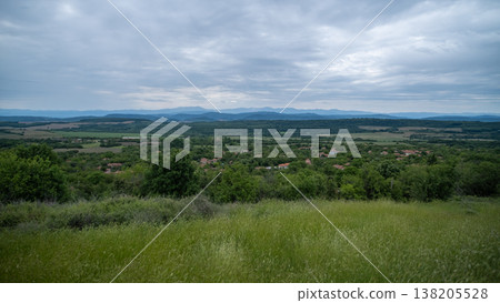 High-Angle View of Green Grassland and Distant Balkan Village Landscape High-Angle View of Green Grassland and Distant Balkan Village Landscape 138205528