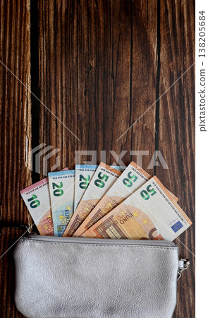 Leader silver partmone with cash euro money. Paper bills in the wallet for commerce concept on the wood background. Leader silver partmone with cash euro money. Paper bills in the wallet for commerce concept on the wood background. 138205684