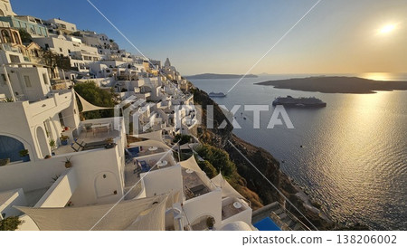 Sunset view over Santorini whitewashed cliffside overlooking the caldera with cruise ships below. Sunset view over Santorini whitewashed cliffside overlooking the caldera with cruise ships below. 138206002