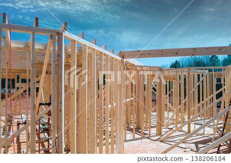 Workers construct wooden frame for new building on construction site in rural area Workers construct wooden frame for new building on construction site in rural area 138206184