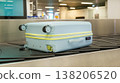Damaged hard shell suitcase with hole and visible interior on baggage conveyor belt airport close up view. 138206520