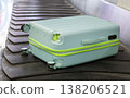 Damaged hard shell suitcase with hole and visible interior on baggage conveyor belt airport close up view. 138206521