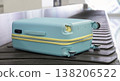 Damaged hard shell suitcase with hole and visible interior on baggage conveyor belt airport close up view. 138206522