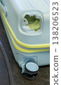 Damaged hard shell suitcase with hole and visible interior on baggage conveyor belt airport close up view. 138206523