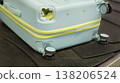 Damaged hard shell suitcase with hole and visible interior on baggage conveyor belt airport close up view. 138206524