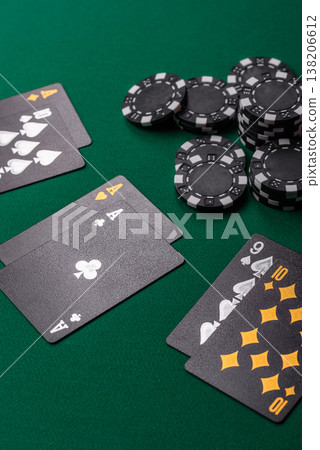 Playing cards and chips on a green cloth, a gambling game of blackjack or baccarat. Cards and chips Playing cards and chips on a green cloth, a gambling game of blackjack or baccarat. Cards and chips 138206612